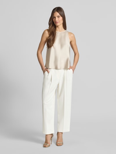 Frauenmodel trägt Wide Fit Stoffhose aus Viskose-Mix mit Bundfalten von Luisa Cerano, cremeweiß mit Bügelfalten, Ganzkörperansicht von vorne.