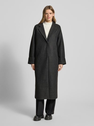 Frauenmodel trägt Mantel mit Reverskragen Modell 'CADDY' von Noisy May in Dunkelgrau, Relaxed-Fit, Eingrifftaschen, Ärmel mit Aufschlag, Ganzkörperansicht von vorne. Rückenlänge 120 cm, Schulterbreite 43 cm, Brustweite 52 cm, Ärmellänge 65 cm bei Größe S.