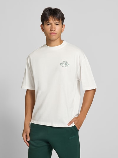 Männermodel trägt Regular Fit T-Shirt aus reiner Baumwolle mit rückseitigem Print von REVIEW in Weiß, Logo-Detail, Nahaufnahme Oberkörper.