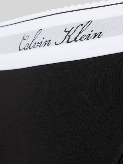 Frauenmodel trägt schwarzen String aus Baumwoll-Mix mit Modal-Anteil Modell 'SCRIPT Thong' von Calvin Klein Underwear, Nahaufnahme Oberkörper.