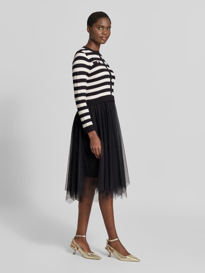 Frauenmodel trägt 'Knielanges Kleid aus Viskose-Mix im 2-in-1-Look' von Apricot, czarno-białe paski na górze, czarna tiulowa spódnica, Mieszanka wiskozy, Linia a, Długość do kolan, efekt 2 w 1, okrągły dekolt, listwa guzikowa, Długość tyłu w rozmiarze S: 107 cm, Szerokość w rozmiarze S: 39 cm, Długość rękawów w rozmiarze S: 58 cm, Ganzkörperansicht z przodu