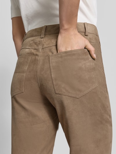 Frauenmodel trägt Stoffhose aus echtem Ziegenvelours von ROTATE in Beige, 5-Pocket-Design, samtige Textur, Nahaufnahme Rückansicht.