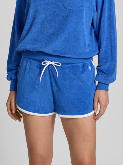 Frauenmodel trägt Regular Fit Sweatshorts aus Baumwoll-Mix von Polo Ralph Lauren in Two-Tone-Optik mit Logo-Stitching, Frottee, Eingrifftaschen, Bundabschluss mit Tunnelzug, Materialverarbeitung aus Baumwoll-Mix, Nahaufnahme Oberkörper.
