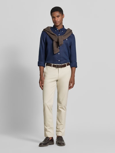 Męski model nosi Slim Fit Chino aus Baumwoll-Mix Modell 'GREENWICH' von Polo Ralph Lauren, beżowy kolor, tekstura gładka, Ganzkörperansicht von vorne.