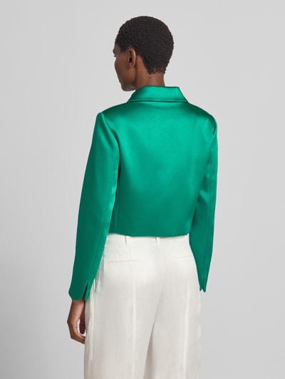 Männermodel trägt Slim Fit Blazer mit Umlegekragen und Knopfleiste von Marc Cain, Mieszanka materiałów z dodatkiem wiskozy, krój slim fit, wykładany kołnierz, listwa guzikowa, długość tyłu w rozmiarze 36: 43 cm, szerokość w rozmiarze 36: 45 cm, długość rękawów w rozmiarze 36: 60 cm, żywe kolory, gładka tekstura. Ganzkörperansicht Rückansicht.