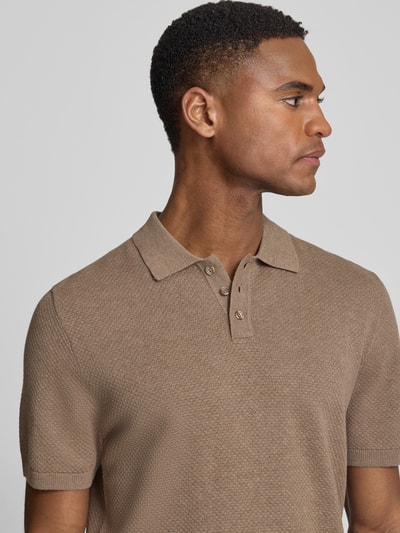Męskamodel nosi koszulkę polo Slim Fit Poloshirt model 'Triton' od Drykorn z bawełny, kołnierzyk polo, krótki rękaw, fakturowany wzór, kolor beżowy, widok na górną część ciała z przodu