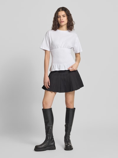 Modelka nosi tailliertes T-Shirt mit Rundhalsausschnitt Modell 'EVELYN' od JJXX, czysta bawełna, krój slim fit, smokowany detal, długość pleców w rozmiarze S: 53 cm, widok całej sylwetki z przodu.