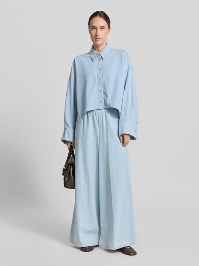 Frauenmodel trägt Relaxed-Fit Damen Hemdbluse in Denim-Optik Modell 'Oshia' von Drykorn aus Reine Baumwolle, Ganzkörperansicht von vorne.