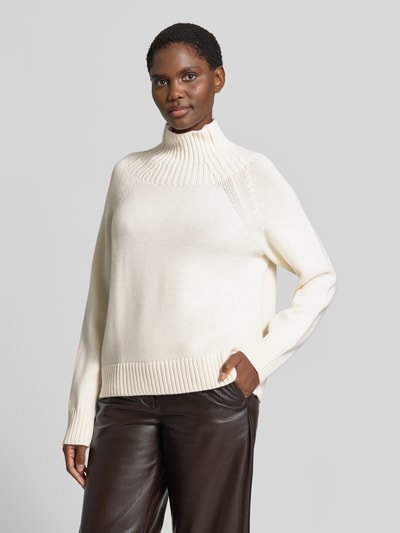 Vrouwenmodel draagt gebreide pullover uit zuiver linnen van MICHAEL Michael Kors, los model, opstaande kraag in riblook, Raglanmouwen, ribboorden, ruglengte maat S 67 cm, mouwlengte maat S 48 cm, crèmekleurig, gladde textuur, vooraanzicht bovenlichaam.