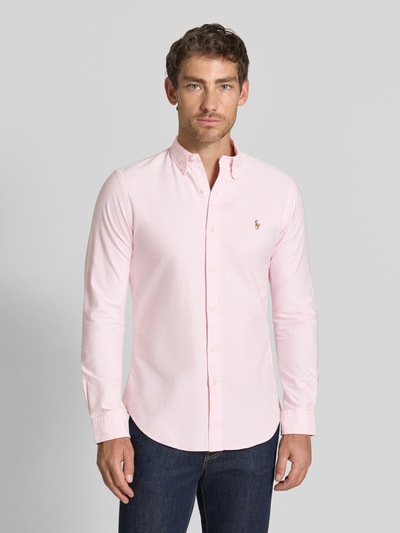 Männermodel trägt Slim Fit Freizeithemd aus reiner katoen van Polo Ralph Lauren in lichtroze met knoopsluiting, Ganzkörperansicht von vorne.