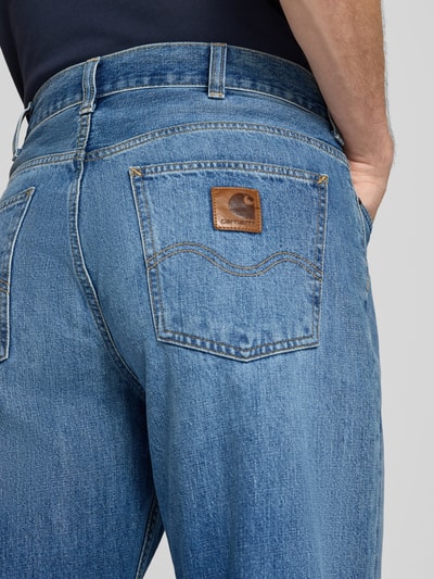 Männermodel trägt Straight Fit Jeans aus reiner Baumwolle Modell "MARLOW" von Carhartt Work In Progress, blau, Nahaufnahme Rückansicht. 5-Pocket-Design, sichtbares Label, strukturierte Denim-Textur, Kontext: Herren Jeans, Gürtelschlaufen, Knopf- und Reißverschluss, Bundweite 45 cm, Innenbeinlänge 79 cm.