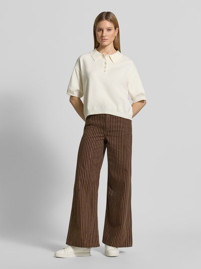 Frauenmodel trägt Straight Fit Jeans im 5-Pocket-Design Modell 'Florchi' von Mango aus Reine Baumwolle, braun gestreift, Ganzkörperansicht von vorne.