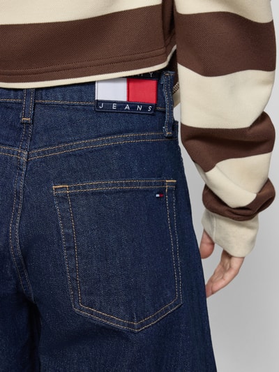 Vrouwenmodel draagt Loose Fit Jeans uit katoenmix van Tommy Jeans, donkerblauw denim, label patch, 5-pocketdesign, detailopname rug.