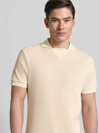 Männermodel trägt Regular Fit Poloshirt aus reiner Baumwolle von Lacoste, Optik: Unifarben, Struktur, Kurzarm, Nahaufnahme Oberkörper
