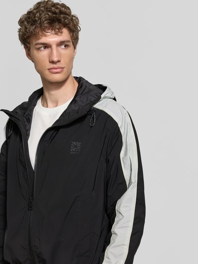 Männermodel trägt Regular Fit Jacke mit Kapuze Modell 'BAVO2621' von HUGO, Optik: Unifarben, Logo-Detail, seitliche Eingrifftaschen, Zweiwege-Reißverschluss, Ganzkörperansicht von vorne.