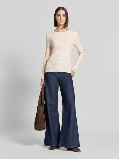 Frauenmodel trägt Slim Fit Strickpullover mit Zopfmuster von Christian Berg Woman, cremefarben, Baumwoll-Mix, Jeans, Ganzkörperansicht von vorne.