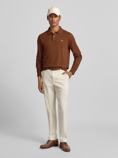 Männermodel trägt Regular Fit Poloshirt mit Label-Stitching von Gant aus reiner Baumwolle, Polokragen, Knopfleiste, Ganzkörperansicht von vorne.
