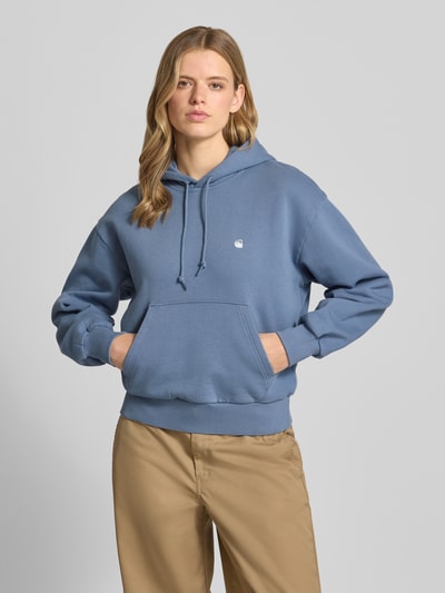 Frauenmodel trägt Oversized Hoodie aus Baumwoll-Mix Modell 'CASEY' von Carhartt Work In Progress, mieszanka bawełny i elastanu, krój oversized, kaptur z tunelem, wyhaftowane logo, obniżone ramiona, prążkowane zakończenia rękawów, kieszeń kangurka, niebieski i beżowy, tekstura gładka, Ganzkörperansicht von vorne
