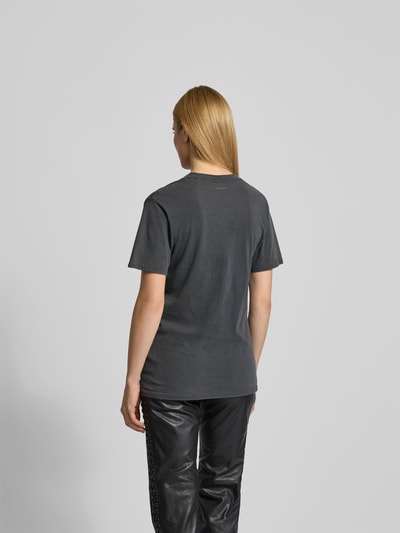 Frauenmodel trägt T-Shirt mit Logo-Print von Anine Bing aus reiner Baumwolle, taillierte Passform, schwarze Farbe, Rückenansicht, Rückenlänge 71 cm, Motiv-Print, Rundhalsausschnitt. Ganzkörperansicht Rückansicht.
