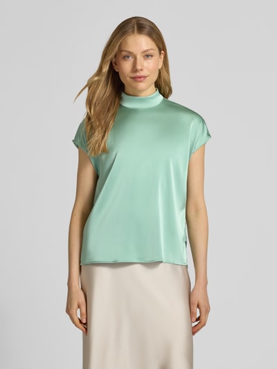 Frauenmodel trägt Blusenshirt mit Stehkragen von Jake*s Collection, mintgrün, Material-Mix mit Stretch-Anteil, Regular-Fit, Rückenreißverschluss, glatte Textur, Rückenlänge bei Größe 38 59 cm, Ganzkörperansicht von vorne.