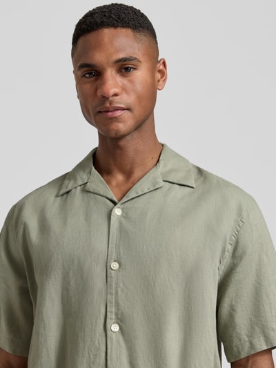 Männermodel trägt Relaxed Fit Freizeithemd aus Leinen-Baumwoll-Mix Modell 'RLXCLAY' von HUGO in Hellgrün, Nahaufnahme Oberkörper.