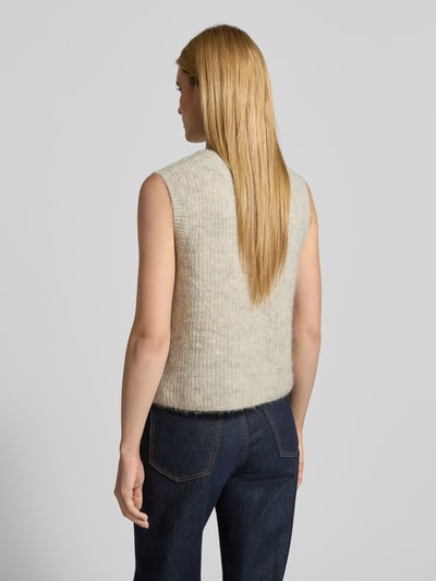 Modelka prezentuje Kamizelkę w imitacji dzianiny od American Vintage, mieszanka materiałów z domieszką alpaki, krój regular fit, prążkowane wykończenia, okrągły dekolt, listwa guzikowa, detal z logo, długość tyłu w rozmiarze S: 49 cm, widok całej sylwetki z tyłu.