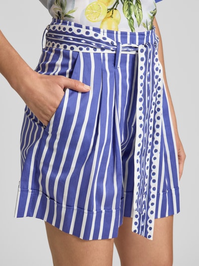Frauenmodel trägt Bermudas mit Bindegürtel und Eingrifftaschen von Marc Cain, blau-weiß gestreift, Reine Baumwolle, Loose-Fit, Nahaufnahme Oberkörper.