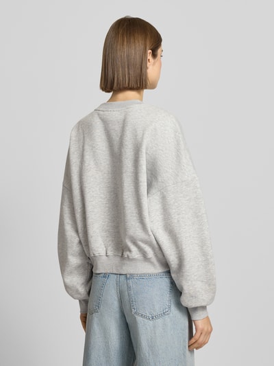 Frauenmodel trägt Sweatshirt mit Label-Print und Rundhalsausschnitt von Review, grauer Baumwoll-Mix, Relaxed-Fit, Ganzkörperansicht Rückansicht