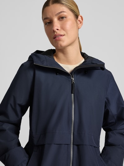 Vrouwenmodel draagt Regular Fit Parka met capuchon van Didriksons in donkerblauw met tweewegritssluiting en steekzakken, Nahaufnahme Oberkörper. Ruglengte maat 36: 87 cm, schouderbreedte maat 36: 41 cm, borstwijdte maat 36: 48 cm, mouwlengte maat 36: 55 cm.