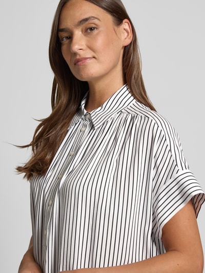 Frauenmodel trägt Relaxed Fit Bluse aus Viskose Modell 'Zafine' von Someday, weiß mit schwarzen Streifen, Nahaufnahme Oberkörper.