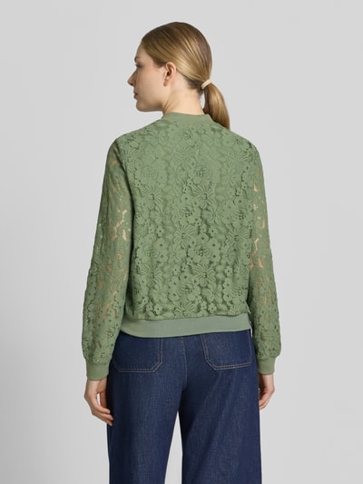 Frauenmodel trägt Regular Fit Blouson aus Baumwoll-Mix Modell 'HONEY' von Vero Moda mit Florales-Allover-Muster, grüner Farbe, gehäkelte Textur, gerippte Bündchen, College-Kragen; Optik:Allover-Muster, Materialverarbeitung: Häkel, Ganzkörperansicht Rückansicht.