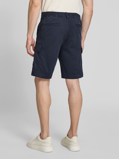 Männermodel trägt Relaxed Fit Cargoshorts aus Baumwoll-Mix Modell 'SISLA' von BOSS Orange, Optik: Unifarben, Ganzkörperansicht Rückansicht.