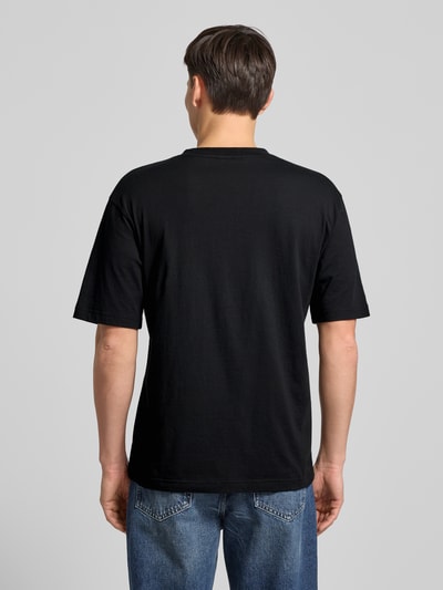 Männermodel trägt Slim Fit T-Shirt aus reiner Baumwolle Modell 'DODGER' von HUGO, Optik: Unifarben, Ganzkörperansicht Rückansicht.