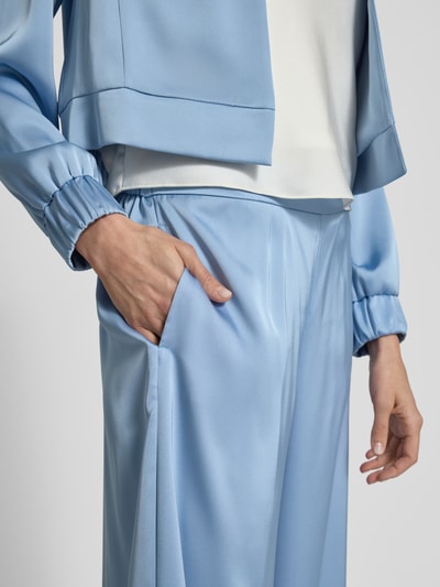 Kobiece modelka nosi Stoffhose mit elastischem Bund von V by Vera Mont, satyna, krój relaxed fit, szeroka nogawka, szerokość w rozmiarze 36: 28 cm, długość nogawki od wewnątrz w rozmiarze 36: 79 cm, jasnoniebieski kolor, gładka tekstura, zbliżenie na górną część ciała