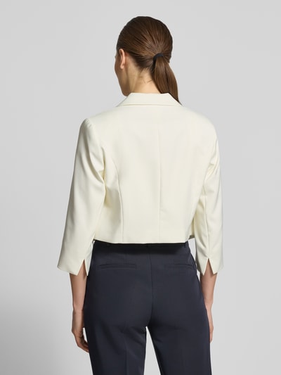 Vrouwenmodel draagt Cropped Blazer met Reverskraag van Betty Barclay in gebroken wit, elastische materiaalmix, ruglengte maat 36: 41 cm, borstwijdte: 40 cm, 3/4-mouw, open voorzijde, achteraanzicht, Ganzkörperansicht Rückansicht.