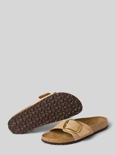 Produktfoto, Slipper aus echtem Nubukleder mit Logo-Detail von Birkenstock für Damen, hellbraune Farbe, abgerundete Passform, offene Ferse, Absatzhöhe 3 cm, Schaftweite 7 cm, strukturierte braune Sohle, Detail-fokussierte Aufnahme.