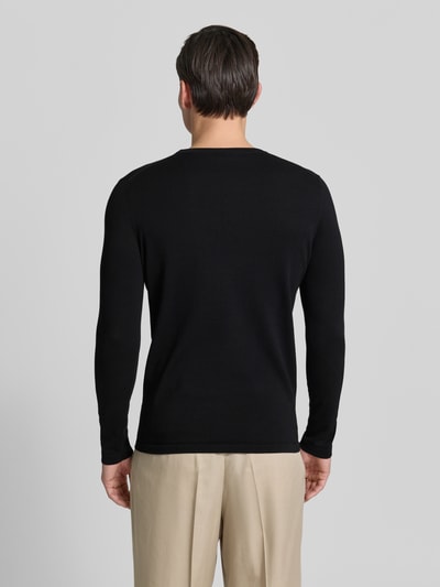 Männermodel trägt schwarzen Slim Fit Pullover in Strick-Optik Modell 'Mino' von Drykorn, reine Baumwolle, Rückenansicht, Ganzkörperansicht Rückansicht.