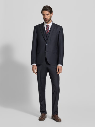 Männermodel trägt Regular Fit Anzughose mit Bügelfalten von bugatti in Dunkelblau, Material-Mix mit Schurwoll-Anteil, Ganzkörperansicht von vorne.