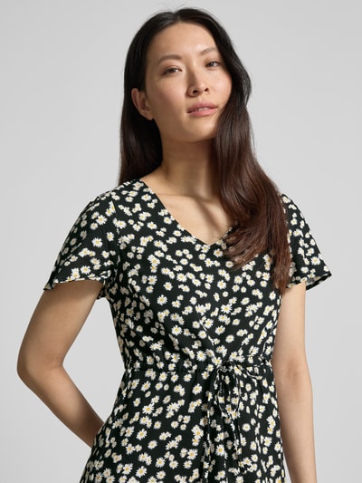 Frauenmodel trägt Tailliertes Freizeitkleid aus reiner Viskose Modell 'EASY JOY' von Vero Moda, Optik:Allover-Muster, V-Ausschnitt, Kurzarm, Nahaufnahme Oberkörper.