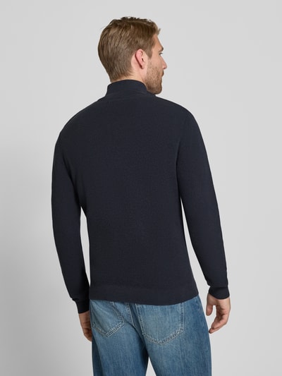 Męski model nosi Slim Fit Troyer aus Baumwoll-Mix von Matinique, kolor ciemny granat, prążkowany pas, krój z długim rękawem, Kołnierz zapinany, mieszanka bawełny, długość tyłu w rozmiarze M: 67 cm, długość rękawów w rozmiarze M: 68 cm. Ganzkörperansicht Rückansicht.