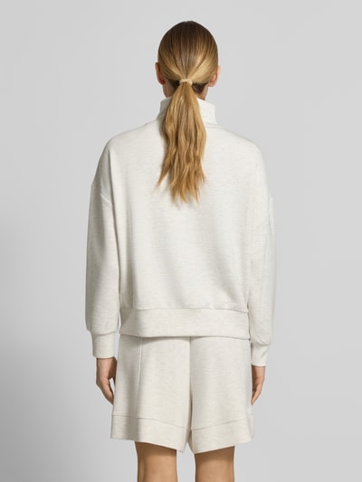 Frauenmodel trägt Sweatshirt aus Viskose-Mix mit Reißverschluss Modell 'hawley' von VARLEY in Creme mit Stehkragen, Regular Fit, Ganzkörperansicht Rückansicht.