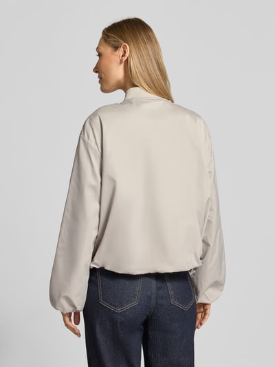 Modelka kobieca ma na sobie Regular Fit Blouson mit Baseball-Kragen od Marc O'Polo, efekt: jednolity kolor, bufiaste rękawy, wpuszczane kieszenie, materiał z recyklingu, zamek błyskawiczny, krój regular fit, kształt kołnierza: baseball, wykończenie: elastyczny tunel, Ganzkörperansicht Rückansicht.