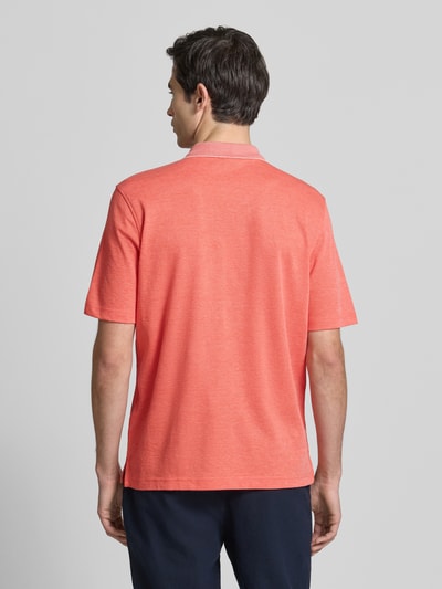 Männermodel trägt Regular Fit Poloshirt mit Brusttasche von Christian Berg Men in Koralle, Baumwoll-Mix, Ganzkörperansicht Rückansicht.