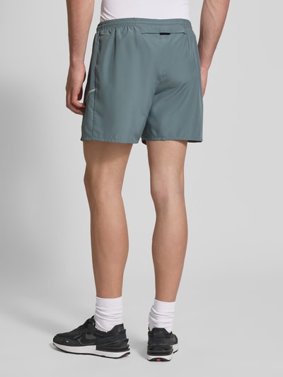 Männermodel trägt Shorts mit seitlichen Eingrifftaschen und Logo-Print von NIKE TRAINING in Loose-Fit, elastischer Bund, Rückansicht