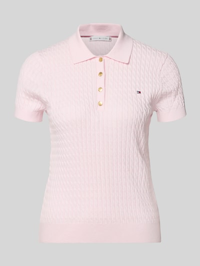 Produktfoto, Slim Fit Poloshirt aus reiner Baumwolle von Tommy Hilfiger in zartem Rosa mit Zopfmuster, kurzem Arm, Polokragen, Strickstruktur, unifarben, Logo-Detail, gerippte Abschlüsse.