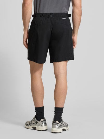 Männermodel trägt Regular Fit Shorts mit Gürtel Modell 'Pathfinder' von The North Face, schwarz, elastischer Bund, Ganzkörperansicht Rückansicht.