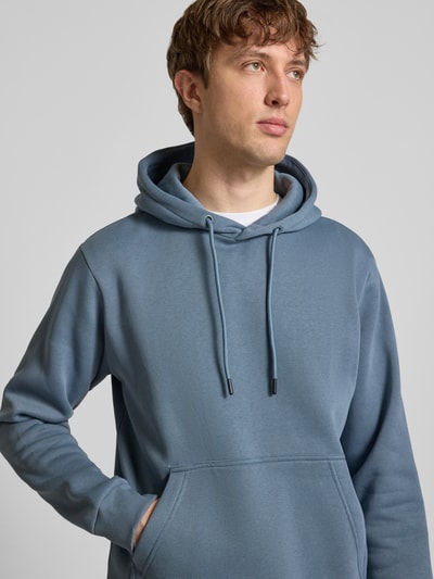 Männermodel trägt Hoodie mit kapuze Modell 'BRADLEY' von JACK & JONES in blauw, katoenmix, los model, kangoeroezak, ribboorden, nahaufnahme bovenlichaam.