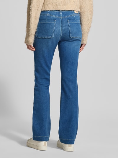 Frauenmodel trägt Flared Fit Jeans mit Flecht-Detail Modell 'Mary' von BRAX aus elastischem Baumwoll-Mix, Aufgesetzte Taschen, blaue Jeansoptik, Ganzkörperansicht Rückansicht, Bundweite 39 cm, Innenbeinlänge 80 cm.