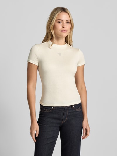 Vrouwenmodel draagt T-Shirt uit viscosemix model 'LICIA' van GUESS, slanke pasvorm, ronde hals, crèmekleur, logo met sierstenen, volledige lichaamsvoorzijde