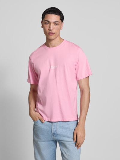 Męski model nosi T-Shirt mit Logo und Rundhalsausschnitt von Jack & Jones, krój regular fit, bawełna ekologiczna, logo, okrągły dekolt, długość tyłu w rozmiarze M: 68 cm, jasnoróżowy kolor, gładka faktura, Ganzkörperansicht z przodu.